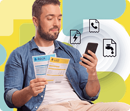 Homem com contas na mão, olhando para o celular