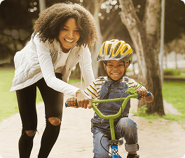 Mulher brincando com uma criança na bicicleta