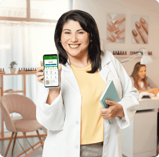 Uma manicure em seu salão, segurando o celular com o Tap On em sua tela